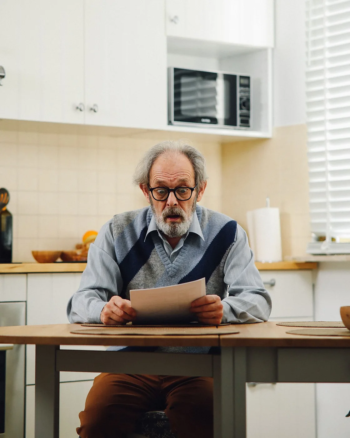 A man reading his order paperwork at the kitchen table