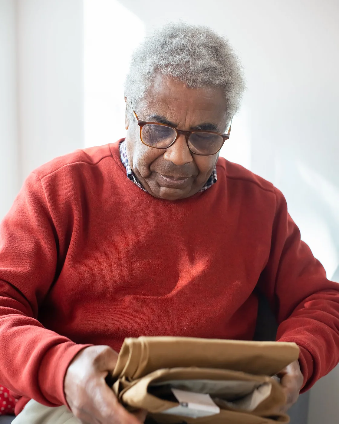 A man opening a supplement delivery and reading the label